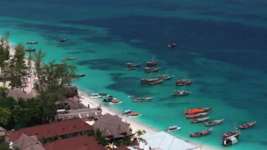 Tropikal deniz kıyısındaki kumlu balıkçı teknelerinin hava manzarası. Hint Okyanusu 'nda yaz tatili, Zanzibar, Afrika. Tekneli manzara, yeşil ağaçlar, saydam yeşil su. Üst görünüm