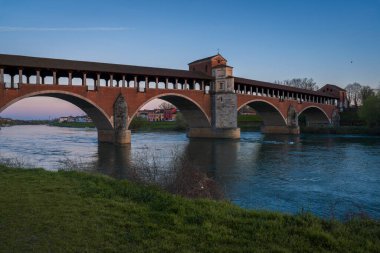 Ponte Koperto (üstü kapalı köprü), günbatımında Pavia, Lombardiya, Pavia, İtalya 'da Ticino Nehri üzerinde yer alan bir köprüdür.