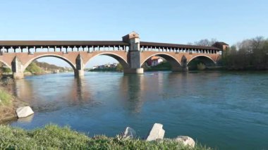 Ponte Koperto (üstü kapalı köprü), güneşli bir günde Pavia 'da Ticino Nehri üzerinde bulunan bir köprüdür.
