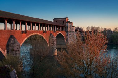 Ponte Koperto (üstü kapalı köprü), günbatımında Pavia, Lombardy, Pavia, İtalya 'da Ticino Nehri üzerinde yer alan bir köprüdür.