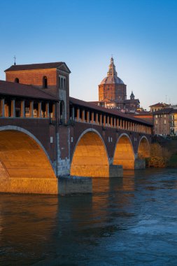 Günbatımında Pavia 'da Ponte Koperto (üstü kapalı köprü) ve Duomo di Pavia (Pavia Katedrali) panoraması, Lombardiya, İtalya. Dikey fotoğraf.