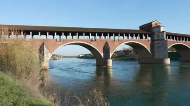 Ponte Koperto 'nun muhteşem manzarası (üstü kapalı köprü) güneşli bir günde Pavia, Lombardiya, Pavia, İtalya' da Ticino Nehri üzerinde bir köprüdür.