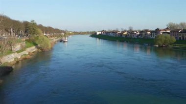 Pavia yakınlarındaki Ticino nehrinin güzel manzarası ve güneşli bir günde demirlemiş bir tekne.