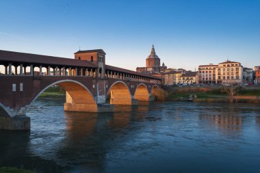 Günbatımında Pavia 'da Ponte Koperto (üstü kapalı köprü) ve Duomo di Pavia (Pavia Katedrali) manzarası, Lombardy, İtalya.