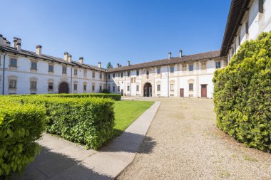 Certosa di Pavia manastırı, bir manastır ve bir sığınak içeren tarihi anıt kompleksi. Yeşil saray ve kilise. Sağdaki Ducale Sarayı, Pavia, İtalya..