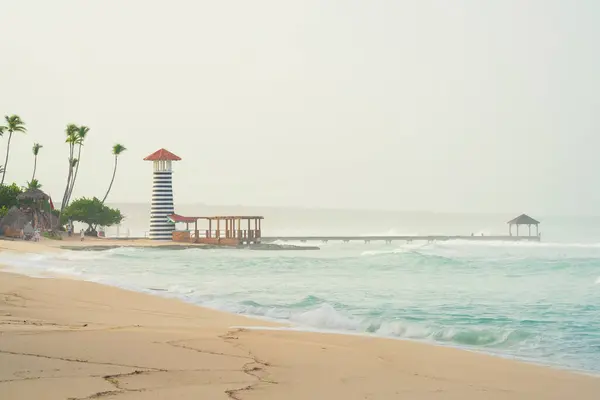 stock image Bayahibe beach at morning, heavy sea and beautiful lighthouse with pier.Dominican republic.