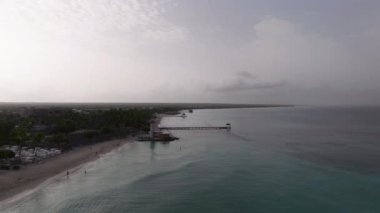 Dominicus plajı, deniz feneri, rıhtım ve güzel kumlu sahil manzarası güneş doğarken, Karayip Denizi. Bayahibe, Dominik Cumhuriyeti.