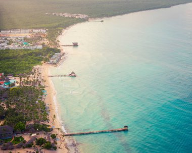 Karayip denizinin havadan görünüşü, kumlu plaj ve güneş doğarken lüks tatil köyü, Bayahibe sahili, Dominik Cumhuriyeti.