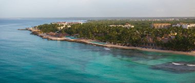 Kumlu sahil manzarası, palmiye ağacı, sahil sandalyesi ve Karayip Denizi, Bayahibe plajı, Dominik Cumhuriyeti