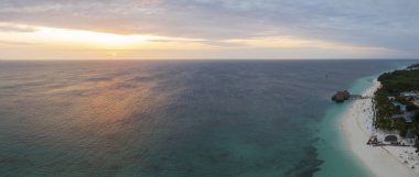 Zanzibar 'ın Panorama' sı kumlu sahil, yeşil su ve günbatımında lüks bir tatil köyü. Zanzibar 'a yaz yolculuğu, Afrika, Tanzanya.