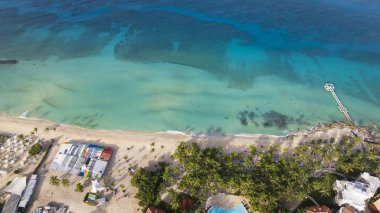Güneşli bir günde Karayip denizi, kumlu sahil, rıhtım ve lüks tatil köyü, Bayahibe sahilleri, Dominik Cumhuriyeti.