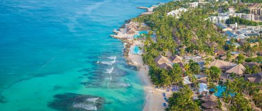 Muhteşem kumlu bir sahil, güneş şemsiyesi, sahil sandalyesi ve Karayip Denizi, Bayahibe plajı, Dominik Cumhuriyeti