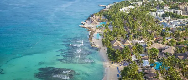 Muhteşem kumlu bir sahil, güneş şemsiyesi, sahil sandalyesi ve Karayip Denizi, Bayahibe plajı, Dominik Cumhuriyeti