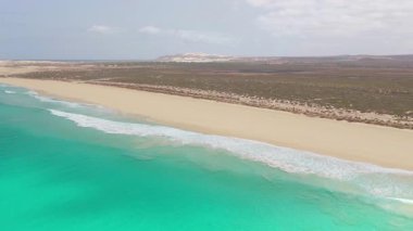 Aerial footage of Santa Monica Beach,showcasing endless white sand, turquoise waves, and a pristine,summer concept,Boa Vista, Cape Verde.