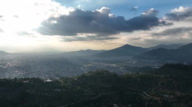 Gün batımında Dağlı Panoramik Hava Şehri ve dramatik Bulutlar. Yüksek kalite 4k görüntü