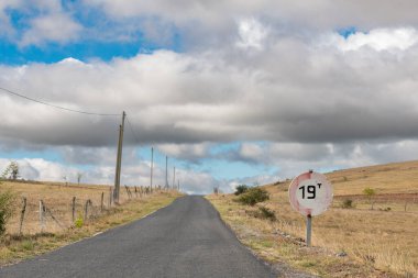 Güneşli bir yaz gününde kırsal kesimde ıssız bir yol. Cevennes, Fransa.