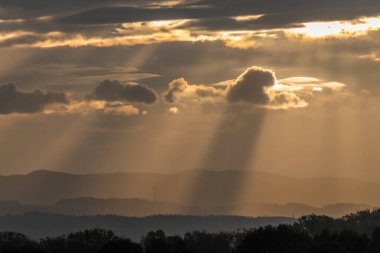 Sabahları güneş ışınları bulutların arasından geçiyor. Alsace, Fransa.