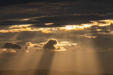 Sabahları güneş ışınları bulutların arasından geçiyor. Alsace, Fransa.