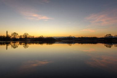 Günbatımında suya yansıyan ağaçların sonbahar manzarası. Sonbahar manzarası. Bas-Rhin, Alsace, Grand Est, Fransa, Avrupa.