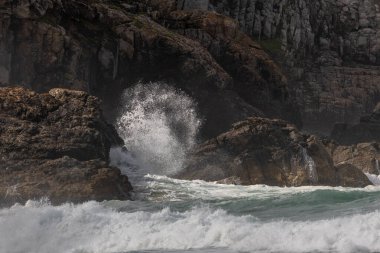 Atlantik Okyanusu 'nun büyük dalgaları bir uçurumun kayalarına çarpar. Camaret, Crozon, Finistere, Brittany, Fransa, Avrupa.