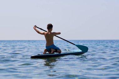 Ege Denizi, Yunanistan 'da Stand Up Paddleboard' da sörf yapan çocuk