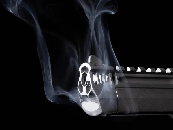 Smoking barrel of a semi-automatic pistol on black