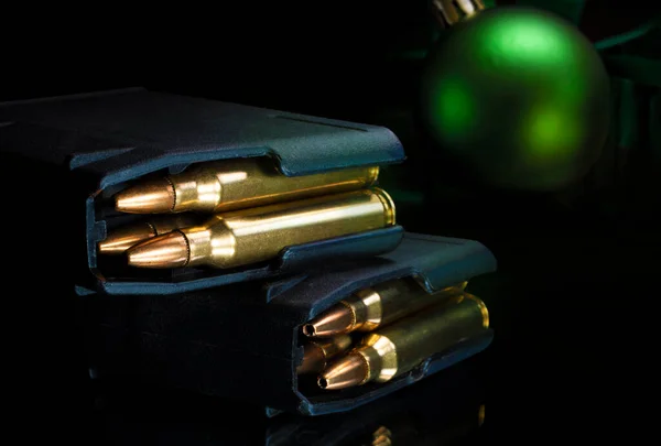 Full assault rifle magazines with Christmas ornament behind