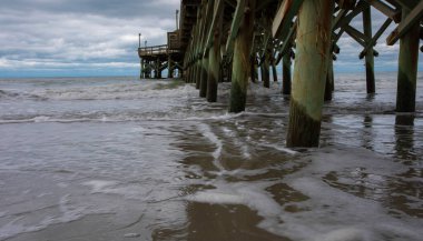 Güney Carolina 'daki Myrtle Sahili' nde bir rıhtımın altından gelgit geliyor.