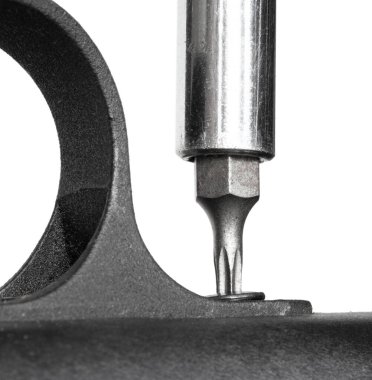 Bir tornavidadaki yıldız başı, bir tetik korumasını çıkarıyor.