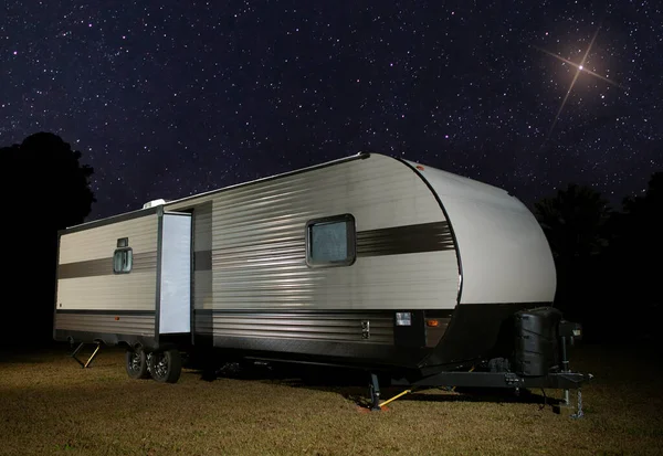 Bright star over a camping trailer on a clear night