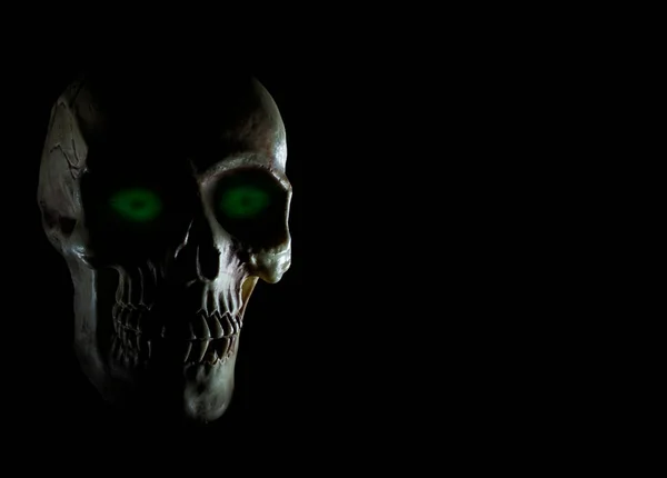 绿色的眼睛闪烁着黑色背景的骷髅 — 图库照片