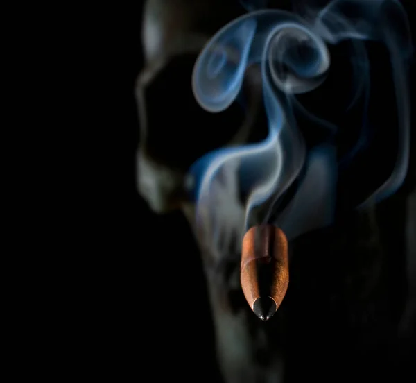 背後に人間の頭蓋骨を持つ視聴者に向かって来る喫煙弾丸 — ストック写真