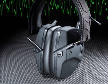 Elektronik aletler ve yeşil sinüs dalgalarıyla çekim ve inşaat için yapılmış kulaklık.