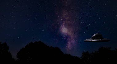 Parlak Samanyolu ve karanlık bir ormanın hemen üstünde UFO 'su olan yıldızlar.