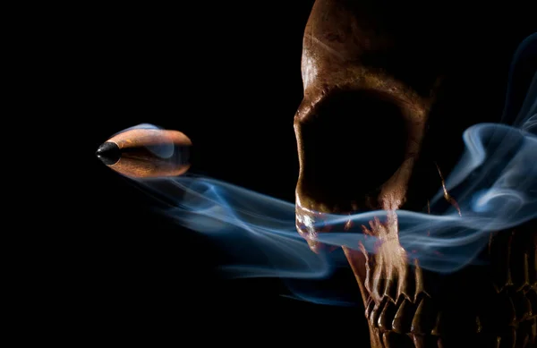 煙と金色の人間の頭蓋骨で飛ぶ弾丸 — ストック写真