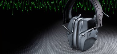 İşitmeyi korumak için elektronik kulaklıklar ve yeşil bir sinüs dalgası