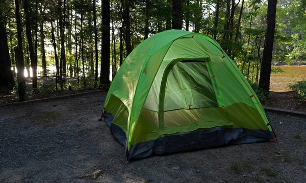 木並みのキャンプ場のテントの後ろにある湖の水を反射する光 — ストック写真