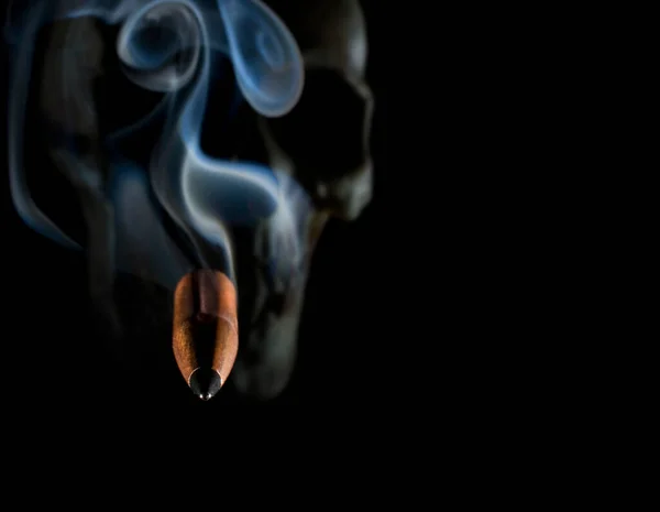 黑漆漆的骷髅后面冒着浓烟的致命子弹 — 图库照片