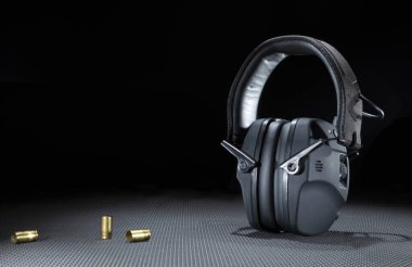 Elektronik işitme korumanın yanında boş tabanca mermisi.