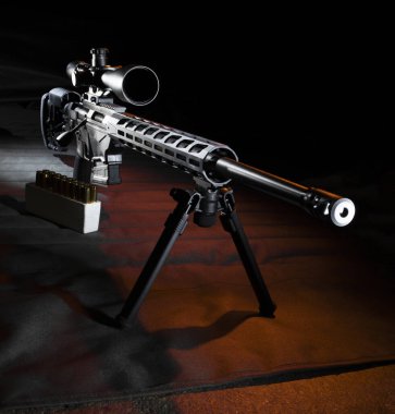 Keskin nişancı tüfeği. Yan tarafında turuncu ışık, bipod monte edilmiş ve paspasında da cephane var.. 