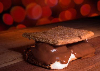 Büyük s 'more odun masada yemeye hazır kırmızı ışıklarla odak dışı bir kutlama için..
