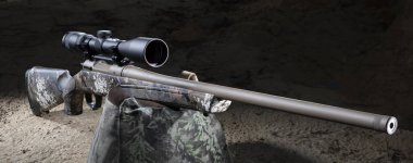 Şafak sökmeden önce kamuflaj kum torbasına dayanmış yüksek dürbünlü bir av tüfeğinin etrafındaki karanlık.. 