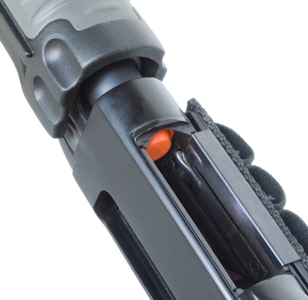 Orange follower showing on a pump action shotgun for protection that indicates the firearm's magazine is empty. 