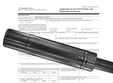 ATF public domain tax form behind a suppressor mounted on a gun barrel clipart