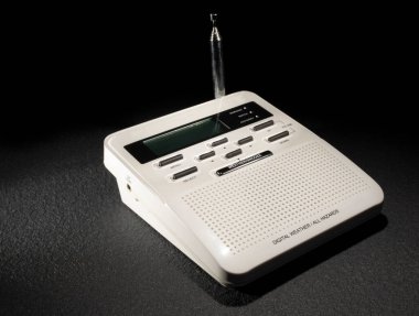 Siyah arka planlı koyu kauçuk bir yüzeyde dijital tehlikeler ve hava durumu radyosu.