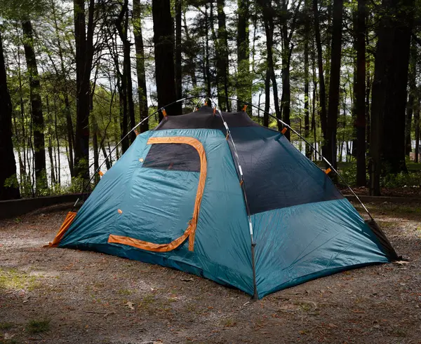 나무를 빛나는 호수와 생활을위한 텐트를 둘러싼 로열티 프리 스톡 이미지