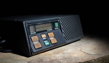 Koyu bir arka planı olan bir kayanın üzerindeki kısa dalga radyo ekranında bir derecho uyarısı gösteriyor..