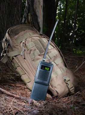 Telsizdeki uzun anten ormanda bir sırt çantasının yanında kanal 40 'ı dinliyor..