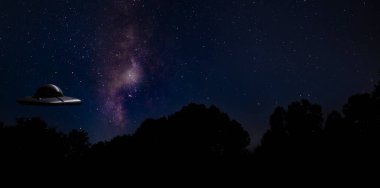 UFO, arka planda Samanyolu olan bir ağaç hattının hemen üzerinde.
