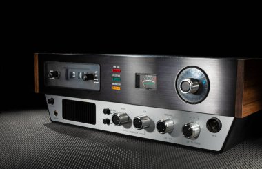 Eski 23 Kanal CB radyosunun yüzünde hoparlör ve saat var. Üzerinde fotokopi alanı olan bir fotoğraf var..